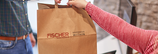 Handing off a branded Fischer Paper Handle Bag